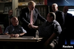 Republican nominee Donald Trump and his running mate Indiana Governor Mike Pence (back R) meet with local labor leaders and union members during a campaign stop in Brook Park, Ohio, Sept. 5, 2016.