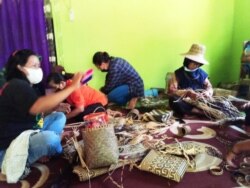 Para perempuan Dayak sedang menganyam rotan (foto: courtesy).