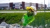 FILE - A single bouquet of flower sits in the rocks across the street from the FedEx facility in Indianapolis, April 17, 2021, where eight people were shot and killed. 