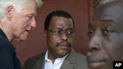 Former U.S. President and UN special envoy to Haiti, Bill Clinton, left, speaks to Garry Conille, center, on the outskirts of Port-au-Prince, Haiti. (August 2011 file photo)