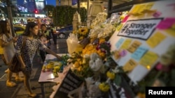 ស្រ្តី​ម្នាក់​ដាក់​ផ្កា​នៅ​ទីសក្ការៈ​ Erawan ទី​ដែល​មាន​ការ​បំផ្ទុះ​គ្រាប់បែក​កាល​ពី​ខែ​សីហា នៅ​កណ្តាល​ទីក្រុង​បាងកក។ 