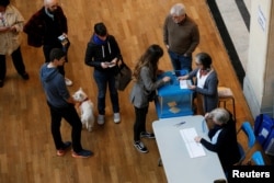 People line up to cast their ballots in the first round of 2017 French presidential election at a polling station in Lyon, France, April 23, 2017.