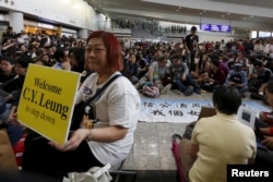 FILE - A protester carries a placard as hundreds of airlines related staff and citizens protest against Hong Kong Chief Executive Leung Chun-ying, who allegedly put pressure on airport staff to help his daughter retrieve a bag left outside of restricted areas, during a demonstration at the arrival hall of the Hong Kong Airport in Hong Kong, China, April 17, 2016.