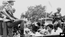 Anggota organisasi pemuda PKI dijaga tentara saat diangkut ke truk terbuka ke penjara di Jakarta, 30 Oktober 1965.