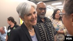 Presumptive Green Party presidential nominee Jill Stein, with her chosen running mate, Ajumu Baraka, in the background, greets supporters at the party's nominating convention in Houston, Aug. 5, 2016. (G. Flakus/VOA)