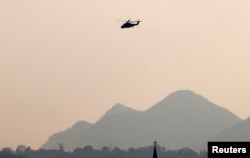 An MI-35M military helicopter flies over Christian church in Lashio, February 19, 2015.