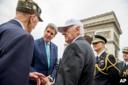 Jon Kerri Parijda urush faxriylari bilan ko'rishmoqda.