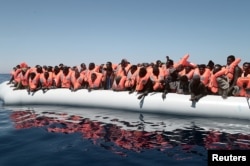 A plastic raft overcrowded with migrants drifts in the central Mediterranean Sea, May 18, 2017.