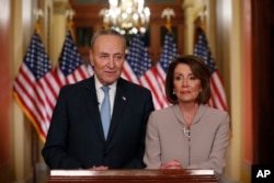 House Speaker Nancy Pelosi, right, and Senate Minority Leader Chuck Schumer pose for photographers after speaking on Capitol Hill in response President Donald Trump's prime-time address on border security, in Washington, Jan. 8, 2019.