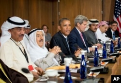 FILE - President Barack Obama sits with Kuwaiti Emir Sheikh Sabah Al-Ahmad Al-Sabah, left center, Secretary of State John Kerry, right center, and other Gulf Cooperation Council leaders and delegations at Camp David, Maryland, May 14, 2015.