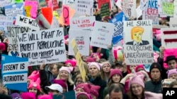 Para perempuan peserta pawai mengenakan topi berwarna merah muda (pink) berkumpul sejak dini hari untuk menggelar protes pada hari pertama kepresidenan Donald Trump, Sabtu, 21 Januari, 2017 di Washington. Protes lain juga digelar secara serentak di beberapa kota besar lain di AS. (AP Photo / Jose Luis Magana)