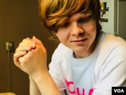 Russian journalist Vitaly Bespalov shows off his 'SOBCHAK' sweatshirt and matching tattoo in St. Petersburg, December 2017. (Photo: C. Maynes / VOA)