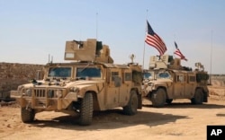 FILE - U.S. forces take up positions on the outskirts of the Syrian town, Manbij, a flashpoint between Turkish troops and allied Syrian fighters and U.S.-backed Kurdish fighters, March 7, 2017.