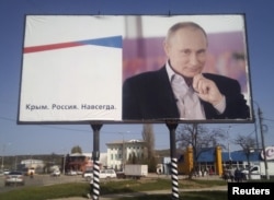 FILE - A billboard with a portrait of Russian President Vladimir Putin is seen on a street in Kerch, Crimea, April 7, 2016. The billboard reads: "Crimea. Russia. Forever." Russia's 2014 annexation of Ukraine's Crimea is among those topping the list of sticking points between Russia and the West.