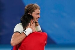 Nemac Aleksandar Zvere teši srpskog tenisera Novaka Đokovića, nakon što ga je pobedio u meču polufinala, na Olimpijskim igrama u Tokiju, 30. jula 2021. (Foto: AP, Patrick Semansky)