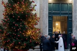 Pope Francis greets a priest as he leaves Sant' Andrea Delle Fratte church following a private visit, in Rome, Dec. 7, 2017.