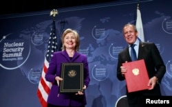 FILE - Then-U.S. Secretary of State Hillary Clinton (L) and Russia's Foreign Minister Sergey Lavrov pose after signing the Plutonium Disposition Protocol during a ceremony at the Washington Convention Center in Washington, Apr. 13, 2010.