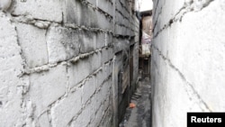 A small alley with a door on the far end on the left leads to a drug den in Manila, Philippines, Feb. 13, 2017.