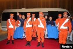 Chinese astronauts Jing Haipeng (left, in blue) and Chen Dong, who landed safely aboard China's Shenzhou 11 spacecraft's re-entry capsule in the northern region of Inner Mongolia, arrive in Beijing, China, Nov. 18, 2016.