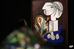 Pablo Picasso is one of the most famous Cubist painters. Here, a woman looks at his painting titled "Nature Morte Aux Tulipes" at an auction in Hong Kong, Oct. 2012.