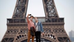 游客戴着口罩在埃菲尔铁塔前留影（路透社）