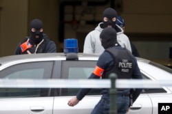 Belgian police officers get into a vehicle outside a court building where Salah Abdeslam, the top suspect in last year's deadly Paris attacks, was expected to appear before a judge in Brussels, Belgium, March 24, 2016.