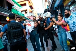 FILE - Turkish police officers arrest protesters, gathered to offer support to workers that were arrested for protesting labor conditions at Istanbul's new airport, in Istanbul, Sept. 15, 2018.