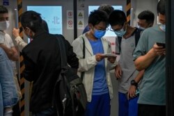Students play online games inside a subway train in Beijing Tuesday, Sept. 14, 2021. China has set new rules limiting the amount of time kids can spend playing online games. (AP Photo/Andy Wong)
