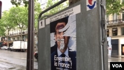 This campaign poster, like many others in Paris, was defaced, May 6, 2017. France's election has been marked by dissatisfaction with both candidates and deep anti-establishment sentiments. (Photo: L. Ramirez/VOA)