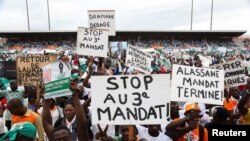 Supporters of Ivory Coast's Coast opposition coalition parties hold signs during a rally to protest against president Alassane Ouattara's bid for a third term in Abidjan, Ivory Coast, Oct. 10, 2020.
