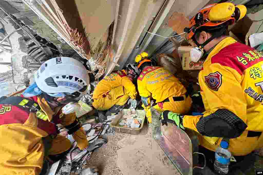 This handout from the Hualien Fire Department taken and released on April 3, 2024 shows members of a rescue team searching for survivors in a damaged building in Hualien, after a major earthquake hit Taiwan's east.