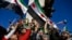 TOPSHOT - Syrian residents in Turkey wave Syrian opposition flags as they celebrate the fall of long-time ruler Bashar al-Assad after rebel fighters took control of the Syrian capital Damascus overnight, in Istanbul on December 8, 2024.