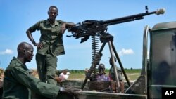 FILE - Government soldiers stand guard by their vehicle on the front lines in the town of Kuek, northern Upper Nile state, South Sudan.