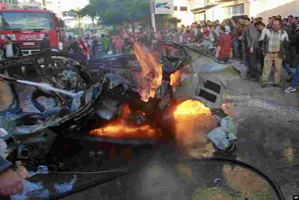 People look at a wreckage of the car in which Ahmed al-Jaabari was killed, Gaza City, November 14, 2012.