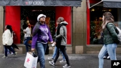 A woman walks out of a Macy's department store in Brooklyn, NY, Nov. 12, 2015.