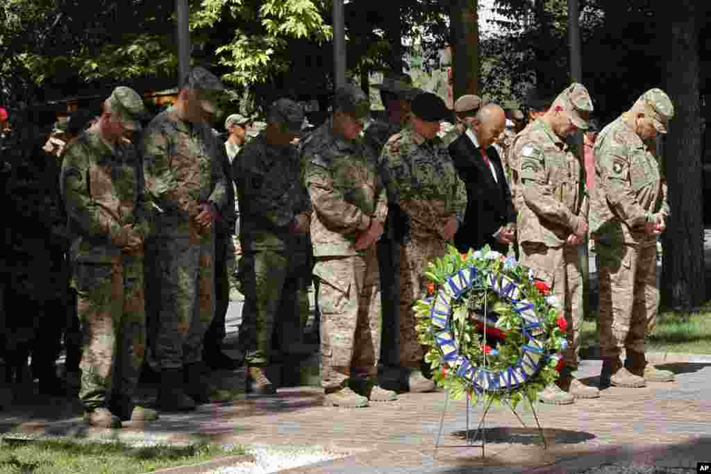 General John F. Campbell, commander of international forces in Afghanistan, second right, gives respect during a ceremony marking Memorial Day at the Resolute Support main headquarters in Kabul on May 25, 2015.