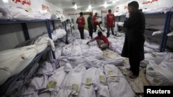 A relative waits while volunteers search for a body of a deceased among people who died due to an intense heat wave in Karachi, Pakistan, June 22, 2015. (PHOTO / REUTERS / Akhtar Soomro)
