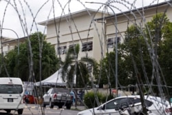 FILE - The exterior of a workers' hostel for Top Glove, the world's largest glove maker, is seen through barricade amid the COVID-19 outbreak in Meru, Selangor state, Malaysia, Nov. 24, 2020.