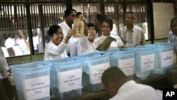 Para petugas pemilu sedang menghitung surat suara yang masuk di sebuah TPS di Yangon (Rangun), Burma (1/4).