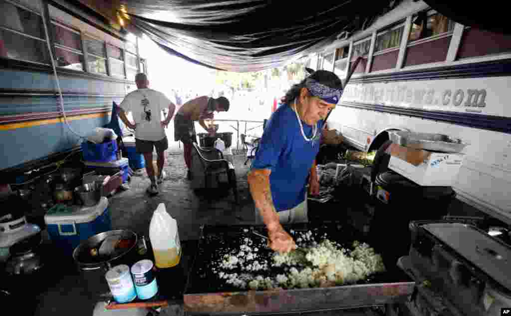 Men prepare food in a protest camp called "Romneyville" outside the convention center.