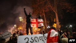 Protesters clash with police during a demonstration against the government's decision to delay European Union membership talks amid a post-election crisis, outside the Georgia Parliament in Tbilisi, Georgia, early on Dec. 1, 2024. 