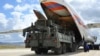 FILE - Military vehicles and equipment, parts of the S-400 air defense systems, are unloaded from a Russian transport aircraft, at Murted military airport in Ankara, Turkey, July 12, 2019. 