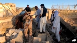 Afghan security members and people work at the site of a suicide attack in Zabul, Afghanistan, Thursday, Sept. 19, 2019. A powerful early morning suicide truck bomb devastated a hospital in southern Afghanistan on Thursday. (AP Photo/Ahmad Wali Sarhadi)