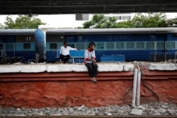 Siddharth Dhage, 10, waits for the train to arrive after filling his containers with water at Aurangabad railway station, India, July 17, 2019.