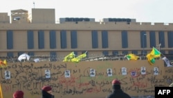 FILE - Portraits of fighters from Kataeb Hezbollah are seen on the wall of the U.S. Embassy in the Iraqi capital, Baghdad, Jan. 1, 2020. Facilities used by Kataeb Hezbollah and Kataeb Sayyid al-Shuhada were destroyed by U.S. airstrikes on Feb. 25, 2021.