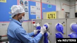 FILE - A worker inspects newly-made gloves at Top Glove factory in Klang, Malaysia, March 3, 2020. (Top Gloves/Anas Zakwan/handout via Reuters)
