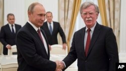 Ruski predsednik Vladimir Putin rukuje se sa američkim savetnikom za nacionalnu bezbednost, Džonom Boltonom, tokom susreta u Moskvi, 27. juna 2018. 