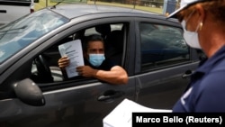 Čovek razgovara sa službenicom pošto je dobio formular za nezaposlene na Floridi (Foto: Reuters/Marco Bello) 