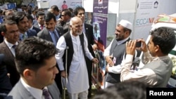 Afghan President Ashraf Ghani, using crutches after recent foot surgery, talks to participants at an exhibition of Afghanistan products during the Regional Economic Cooperation Conference of Afghanistan (RECCA) in Kabul, Afghanistan, Sept. 4, 2015.