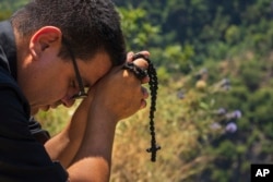 Lebanese priest Hani Tawk prays outside the Qannoubine Monastery, hidden deep in the Kadisha Valley, a holy site for Lebanon's Maronite Christians, in Bcharre, Lebanon, on July 22, 2023.